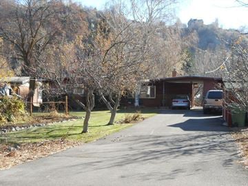 Logan house for rent - A car is parked in front of a house on a tree-lined street.