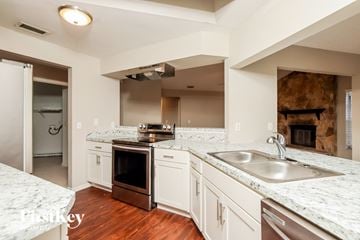 Palm Bay house for rent - a kitchen with white cabinets and granite counter tops and a sink