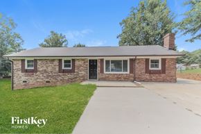 Gastonia house for rent - a small brick house with a driveway and grass