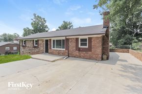 Gastonia house for rent - a small brick house with a driveway and a brick wall