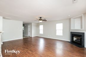 Winston-Salem house for rent - a living room with a fireplace and a ceiling fan
