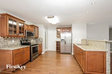 Winston-Salem house for rent - a kitchen with wooden cabinets and granite counter tops and stainless steel appliances
