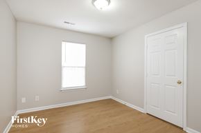 Winston-Salem house for rent - a bedroom with white walls and a wooden floor and a white door