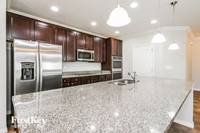 Haines City house for rent - a kitchen with a marble counter top and stainless steel appliances