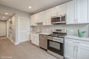 Chicago apartment for rent - A modern kitchen with white cabinets and stainless steel appliances.