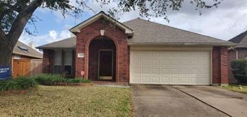 Stafford house for rent - a brick house with a white garage door
