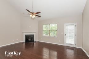 Charlotte house for rent - A spacious room with a fireplace and a ceiling fan.