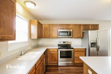 Greenfield house for rent - a kitchen with wooden cabinets and stainless steel appliances
