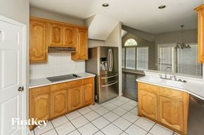 Fort Worth house for rent - a kitchen with wooden cabinets and stainless steel appliances