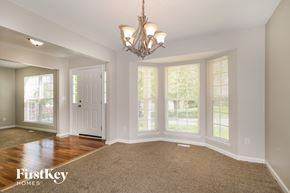 Lake Saint Louis house for rent - a dining room with a chandelier and large windows