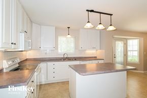 Lake Saint Louis house for rent - a large kitchen with white cabinets and a counter top