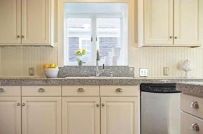 Salt Lake City house for rent - a kitchen with white cabinets and a sink and a window