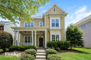 Charlotte house for rent - a yellow house with white columns and a black door