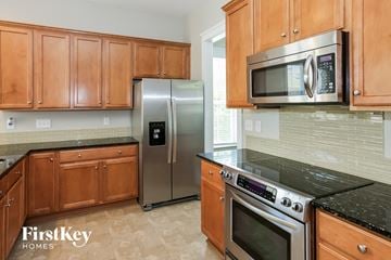 Charlotte house for rent - a kitchen with stainless steel appliances and wooden cabinets
