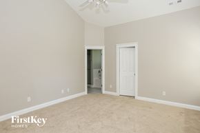 Charlotte house for rent - a bedroom with a carpeted floor and a door to a bathroom