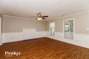 Winston-Salem house for rent - A spacious room with wooden floors and a ceiling fan.