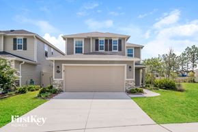 Jacksonville house for rent - a beige house with a garage door and a driveway