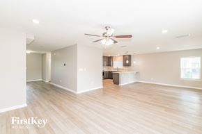 Jacksonville house for rent - a living room and kitchen with wood flooring and a ceiling fan