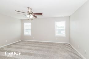 Jacksonville house for rent - a spacious bedroom with carpet and a ceiling fan