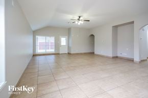 Houston house for rent - an empty living room with tiled floors and a ceiling fan