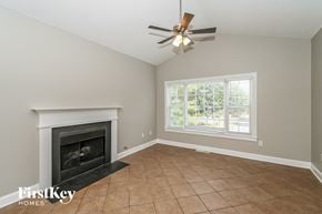 Temple house for rent - a living room with a fireplace and a ceiling fan