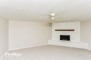 Burleson house for rent - A living room with a fireplace and a fan on the ceiling.