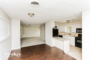 Burleson house for rent - A kitchen with a white island and black appliances.