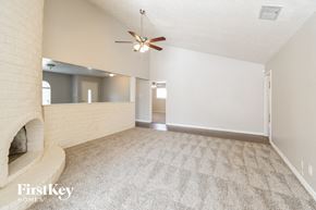 Houston house for rent - A spacious room with a fan and a fireplace.