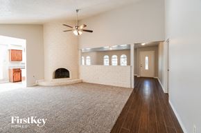 Houston house for rent - A spacious living room with a fireplace and a carpeted floor.