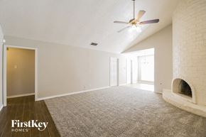 Houston house for rent - A spacious room with a ceiling fan and a fireplace.