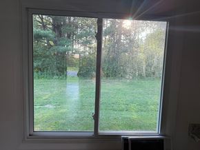 Weston apartment for rent - A window with a view of a green lawn and trees.