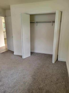Weston apartment for rent - A white closet with a grey carpet is open.