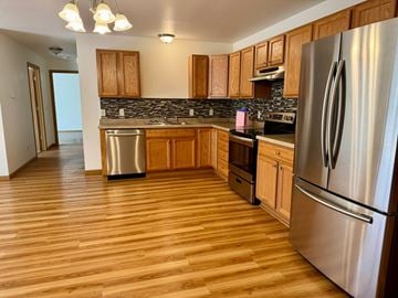 Kronenwetter apartment for rent - A kitchen with wooden cabinets and a stainless steel refrigerator.