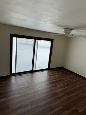 Wausau apartment for rent - A room with a ceiling fan and sliding glass doors.