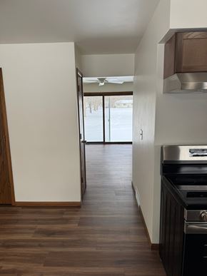 Wausau apartment for rent - A kitchen with a stove top oven and a wooden floor.