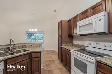 Orlando house for rent - A kitchen with brown cabinets and a white microwave above the stove.