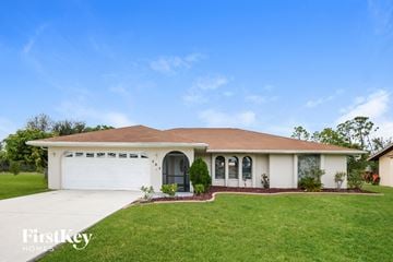 Punta Gorda house for rent - a white house with a lawn and a garage