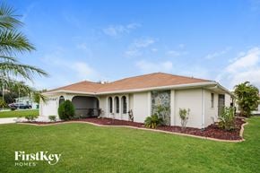 Punta Gorda house for rent - a house with a lawn and a palm tree