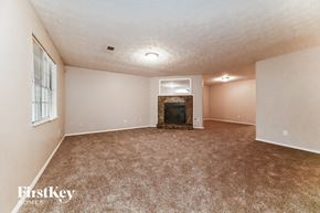 Atlanta house for rent - A spacious living room with a fireplace and carpeted floor.