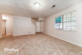 Atlanta house for rent - A spacious room with a carpeted floor and a window with blinds.