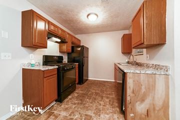 Atlanta house for rent - A kitchen with wooden cabinets and black appliances.