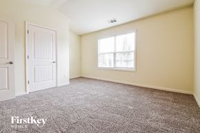 Buford house for rent - a bedroom with carpet and a window and a door