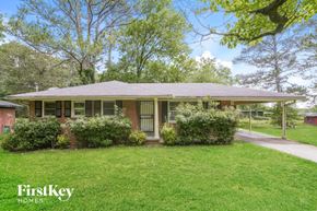 Forest Park house for rent - a small brick house with a lawn and trees