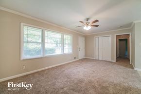 Forest Park house for rent - an empty living room with a ceiling fan and a window
