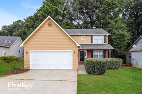 Riverdale house for rent - A house with a brown roof and a white garage door is for sale.