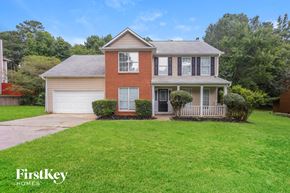 Hampton house for rent - A house with a red brick facade and a white garage door is for sale.