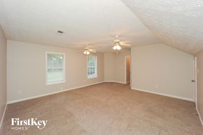 Hampton house for rent - A spacious room with a ceiling fan and two windows.