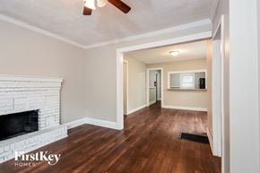 Atlanta house for rent - a living room with a white brick fireplace and wood flooring