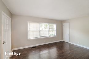 Decatur house for rent - A room with wooden floors and a window with blinds.