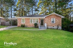 Decatur house for rent - a small brick house with a green lawn and a backdoor